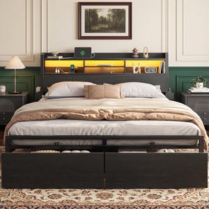 May include: A black bed frame with a built-in headboard featuring integrated storage shelves and warm yellow LED lighting. The bed includes two large pull-out storage drawers at the base, a white mattress, and a beige comforter with two pillows.
