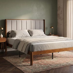 May include: A wooden bed frame with a tall, light gray upholstered headboard featuring vertical channel tufting. The bed is dressed with light gray pillows and a matching throw blanket, flanked by two wooden nightstands with lamps.