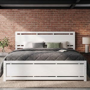 May include: A white wooden bed frame featuring a horizontal slat design on both the headboard and footboard. The bed is dressed with a dark gray quilted comforter, two white pillows, one gray pillow, and one green rectangular accent pillow.