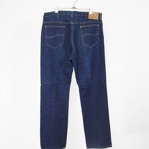 Op de afbeelding: Een donkerblauwe spijkerbroek met een bruin lederen Lee-label op de rechter achterzak.