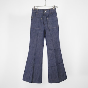 Op de afbeelding: Een donkerblauwe denim broek met wijde pijpen en grote zakken aan de voorkant. De broek hangt aan een metalen hanger.