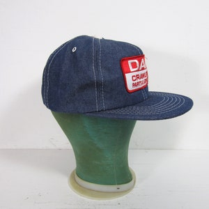 Puede incluir: Una gorra de b&eacute;isbol de mezclilla azul con una visera cosida blanca y un parche rojo y blanco que dice "DANA CRAWLER PARTS & SERVICE".