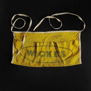 May include: Yellow canvas tool apron with white trim and the word "WICKES" printed in green inside an oval.