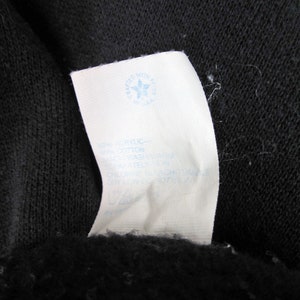 May include: White care label with blue text and a blue star logo that says "crafted with pride" and "baskin". The label has instructions for washing and drying the garment.