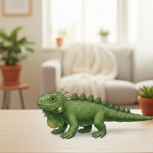 May include: A detailed illustration of a green iguana with textured skin, a spiky dorsal crest, and a tan throat. The iguana is depicted in a lifelike pose, with its legs and tail extended. The reptile is on a light-colored surface.
