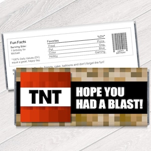 May include: A Minecraft-themed chocolate bar wrapper with a red and black TNT design and the text "HOPE YOU HAD A BLAST!"  The wrapper also includes a nutrition facts label with a list of favorites, including pizza, dog, blue, and gaming.