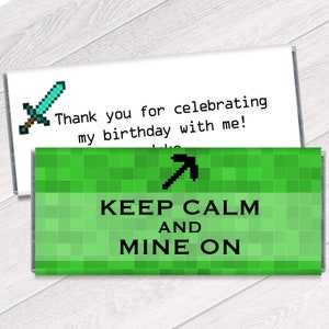 May include: A green and black Minecraft-themed chocolate bar wrapper with a pickaxe and the text "Keep Calm and Mine On".