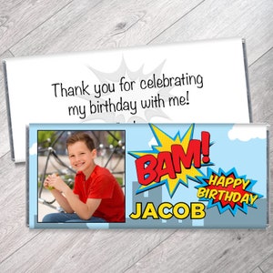 May include: A blue and red comic book style birthday chocolate bar wrapper with the words "BAM!" and "Happy Birthday" in a red and yellow speech bubble. The wrapper also includes a photo of a boy and the name "JACOB".