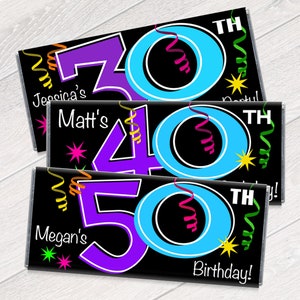 May include: Three chocolate bar wrappers with black backgrounds and colorful designs. The wrappers feature the numbers 30, 40, and 50 with the word "TH" and the word "Birthday!" on the bottom. The wrappers also have the names "Jessica's", "Matt's", and "Megan's" on them.