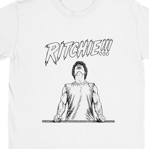 May include: A white short-sleeved t-shirt featuring a black and white graphic illustration of a muscular figure with head tilted back and hands resting on a ledge. Above the figure, the text RITCHIE!!! is printed in a jagged, comic-style font.