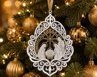 Pode incluir: Um enfeite de Natal de renda branca com uma cena de natividade com três figuras e uma estrela central. O ornamento tem uma borda intrincada de volutas e está suspenso por uma fita dourada, com bordados detalhados da sagrada família.