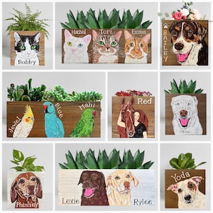 May include: Wooden planters with painted portraits of pets, including cats, dogs, and a horse. Each planter features a different pet's name, such as "Bobby," "Bailey," and "Red." The planters are filled with greenery.