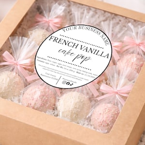 May include: A square cardboard box with a clear window containing individually wrapped cake pops. Each pop is tied with a light pink ribbon. A circular label reads: YOUR BUSINESS NAME, FRENCH VANILLA cake pop, Net Wt: 10 oz (283 g).