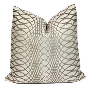 Könnte beinhalten: Ein weißes und braunes Kissen mit geometrischem Muster und einem dezenten Schimmer.