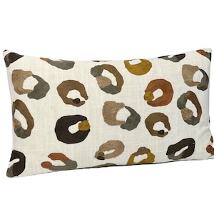 May include: Rectangular cushion featuring a cream-coloured background with an embroidered leopard print pattern in shades of brown, tan, and olive green. A home decor item.