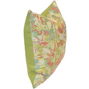Op de afbeelding: Een groen en cr&egrave;mekleurig kussen met een bloemenpatroon in tinten roze, oranje en groen.
