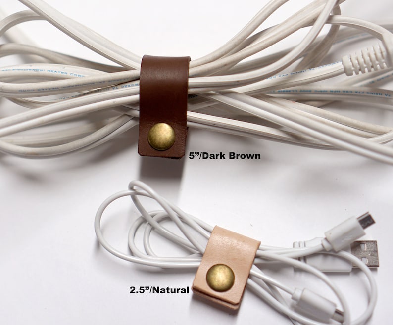 Puede incluir: Dos organizadores de cables de cuero, uno marr&oacute;n oscuro y otro natural, con detalles en lat&oacute;n. El organizador marr&oacute;n oscuro mide 5 pulgadas de largo y el organizador natural mide 2,5 pulgadas de largo.