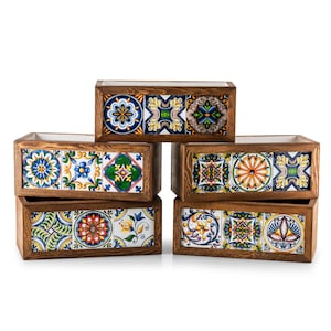 May include: Six rectangular wooden planters with colorful, patterned ceramic tile fronts. The tiles feature floral and geometric designs in shades of blue, yellow, green, and orange. The wooden frames have a natural wood grain finish.