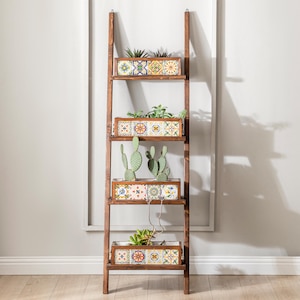 Könnte beinhalten: Ein hohes Leiterregal aus dunkelbraunem Holz mit vier horizontalen Ablagen. Jede Ablage enthält einen rechteckigen Pflanzkasten, der mit bunten, komplizierten geometrischen und floralen Fliesenmustern verziert ist. Verschiedene grüne Sukkulenten und Kakteen sind darin gepflanzt.