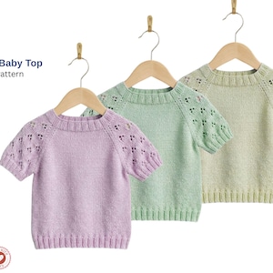 May include: Three pastel-colored baby tops hanging on wooden hangers. The tops are light purple, mint green, and pale yellow. Each has short sleeves with a decorative openwork pattern. The text "Semila Baby Top Knitt Pattern" is visible.