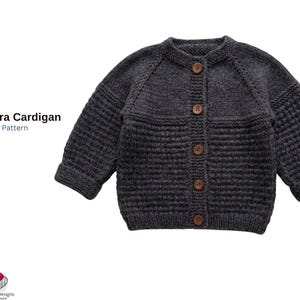 Puede incluir: Un patrón de tejido de cárdigan Marmara gris oscuro. El cárdigan de punto tiene cuello redondo, mangas largas y botones de madera. El texto "Marmara Cardigan Knitt Pattern" está en el lado izquierdo de la imagen.