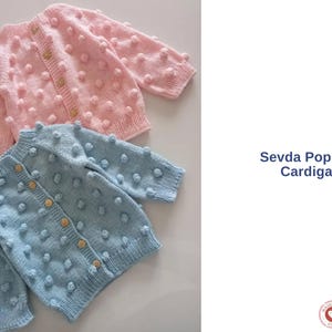 Puede incluir: Dos cárdigans hechos a mano con punto de palomitas, uno rosa claro y otro azul claro. Cada cárdigan tiene botones de madera y un diseño texturizado con forma de pompón. El texto "Sevda Popcorn Cardigan" es visible.