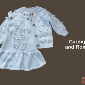 Puede incluir: Conjunto de cárdigan y pelele de punto azul claro. El cárdigan tiene botones de madera y pequeñas bolitas con textura. El pelele presenta una falda con volantes y patrones decorativos de flores y hojas. El texto "Cardigan and Romper" es visible.