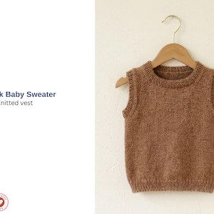 May include: A brown knitted baby vest, hanging on a wooden clothes hanger. The vest features a round neck and ribbed detailing. The text "Yumak Baby Sweater Knitted vest" is visible on the left side of the image.