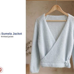 Può includere: Una giacca a portafoglio lavorata a maglia azzurra, appesa a una gruccia di legno. La giacca ha maniche lunghe e una chiusura con fiocco in vita. Il testo "Miss Sumela Jacket" e "Knitted jacket" sono visibili.