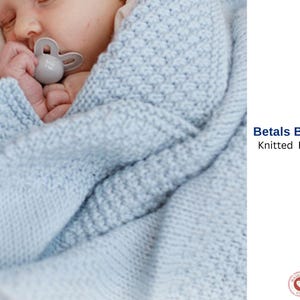 May include: A baby wrapped in a light blue knitted blanket. The blanket has a textured pattern and is labeled "Betals Blanket Knitted Pattern". The baby is also holding a gray pacifier.