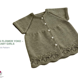 May include: Olive green knitted baby girls' yoke with short sleeves and a scalloped hem. The yoke is buttoned down the front with four white pearl buttons. The text "ERANTIS FLOWER YOKE - BABY GIRLS" is visible.