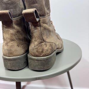 K&ouml;nnte beinhalten: Ein Paar braune Lederstiefeletten mit Used-Optik, Schn&uuml;rung vorne, seitlichem Rei&szlig;verschluss, Zuglasche an der Ferse und einer dicken, flachen Gummisohle. Die Stiefel verf&uuml;gen &uuml;ber einen strukturierten, wildlederartigen Schaftabschluss.