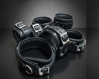Set di 7 manette imbottite in vera pelle con chiusura di sicurezza, ideali per giochi sessuali tra adulti.
