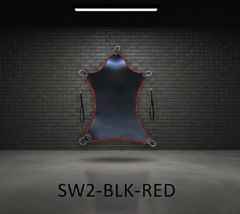 Black, star-shaped sling with red edging and metal rings. The sling has two black straps and is suspended in a room with a brick wall. The text "SW2-BLK-RED" is at the bottom.