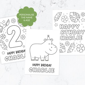 May include: Three white rectangular colouring pages with black line art. One page features a large number 2, a parrot, and flowers. Another shows a hippo wearing a party hat. The third displays the text HAPPY BIRTHDAY CHARLIE with tropical leaves.