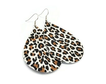 May include: A pair of teardrop-shaped earrings with a white background and a brown and black leopard print.