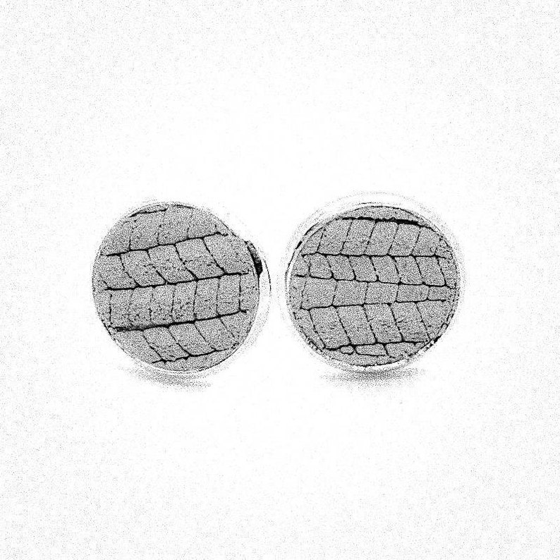 May include: A pair of round, silver cufflinks with a textured, woven pattern in a dark gray color.