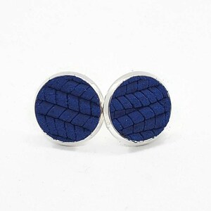 May include: A pair of blue leather earrings with a woven pattern. The earrings are silver-toned and have a circular shape.