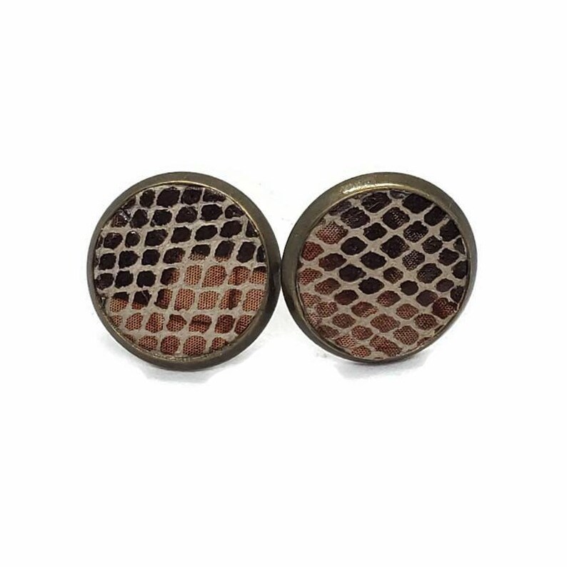 May include: A pair of round, bronze-colored earrings with a snakeskin pattern. The pattern is a light brown and dark brown color.
