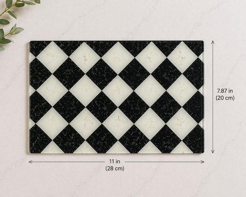 May include: Rectangular cutting board with a black and white checkered pattern. The board measures 11 inches (28 cm) long and 7.87 inches (20 cm) wide. The design features alternating black and white diamond shapes.