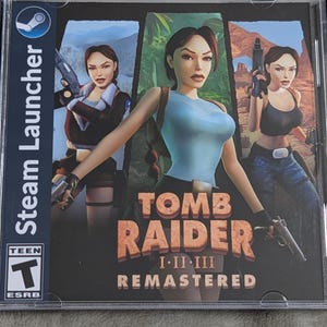May include: Tomb Raider I-II-III Remastered game case. The cover art features a central image of Lara Croft in a blue top, flanked by two other images of her. The Steam Launcher logo is visible on the side.