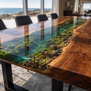 May include: A rectangular dining table featuring a live edge wood slab with a central river design made of clear blue resin. The resin section contains embedded green moss, small brown pinecones, and smooth river stones, supported by black metal legs.