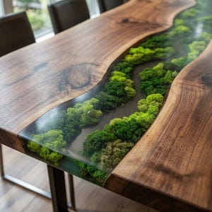 Könnte beinhalten: Ein handgefertigter Esstisch aus Holz mit einem einzigartigen Design. Der Tisch hat eine Tischplatte aus Walnussholz mit lebendiger Kante und einen Fluss aus grünem Moos, der in klarem Harz eingeschlossen ist. Er wird von schwarzen Metallbeinen getragen.