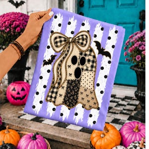May include: A rectangular garden flag featuring a light purple background with white vertical stripes and black polka dots. The center displays a ghost graphic composed of various beige, black, and white patterned fabric patches, topped with a large plaid bow and flanked by two black bat silhouettes.