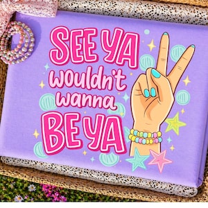 May include: A lavender pillow with the text "SEE YA wouldn't wanna BE YA" in pink. A hand with a peace sign is illustrated on the right. The hand has blue fingernails and is wearing bracelets. Stars and circles decorate the pillow.