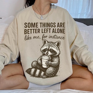 Mapache divertido con café PNG, diseño de camiseta "Algunas cosas es mejor dejarlas en paz", camiseta occidental PNG, mapache coqueto, camiseta linda pero salvaje PNG