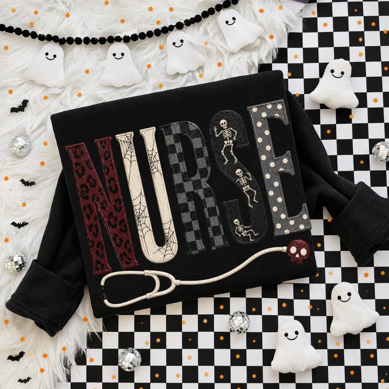 May include: A black long-sleeve shirt featuring the word NURSE in large letters. Each letter has a unique pattern: leopard print, spider webs, checkered, skeletons, and polka dots. A stethoscope with a skull-shaped chest piece is below.