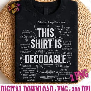 Op de afbeelding: Een zwart t-shirt met witte tekst die THIS SHIRT IS DECODABLE leest. Het ontwerp bevat diverse taalkundige annotaties, pijlen en fonetische regels zoals Silent-e Jump Back Rule, sh Digraph, r-controlled ir en Schwa sound.