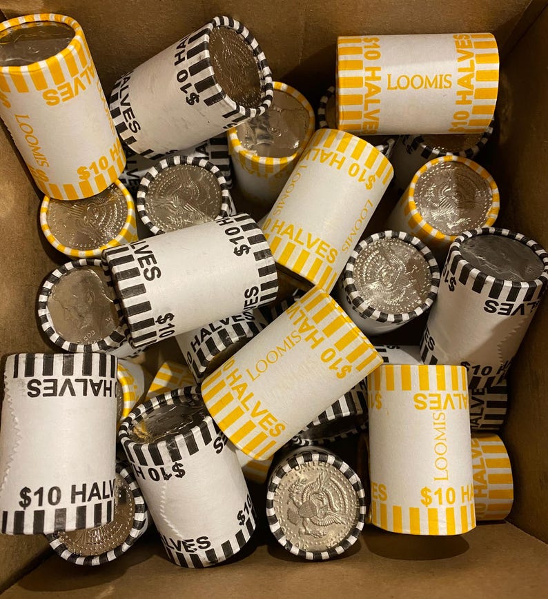 May include: A collection of paper rolls filled with silver half dollar coins. The rolls are labeled "$10 HALVES" and "LOOMIS" in black and yellow. Some coins are visible, showing the profile of a person.