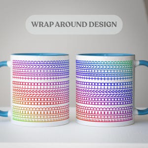 Op de afbeelding: Twee witte keramische mokken met een wikkelontwerp met een regenboogverloop van geometrische patronen. De mokken hebben blauwe handvatten en interieurs, en de tekst "WRAP AROUND DESIGN" staat boven de mokken.